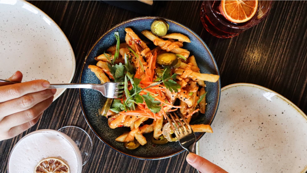 Bahn Mi Fries on a table with 2 forks 
