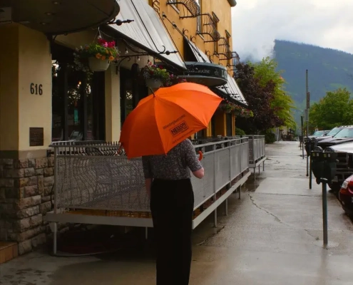person standing outside of the adventure hotel holding an umbrella